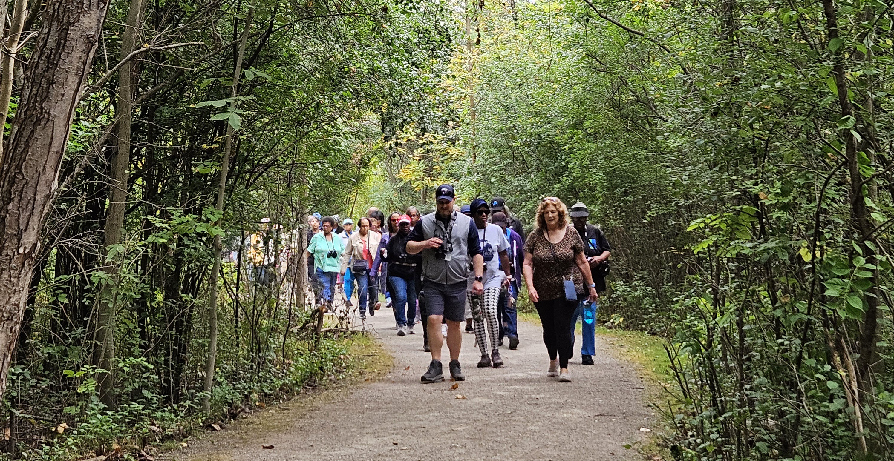 Picture of a group walking toward the viewer along a tree lined path at Carpenter Lake Nature Preserve